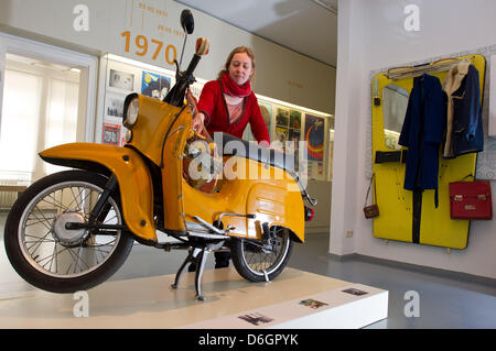 Katja Boehme vom Dokumentationszentrum Alltagskultur der DDR (Dokumentation Center der Alltagskultur der DDR) steht neben einer Schwalbe moped in der neuen Dauerausstellung in München, Deutschland, 22. Februar 2012. Die Ausstellung "Alltag: DDR" ("Alltag: DDR") ist geöffnet vom 25. Februar 2012 mit Objekten, Interviews und Filmausschnitten über das tägliche Leben im Osten G Stockfoto