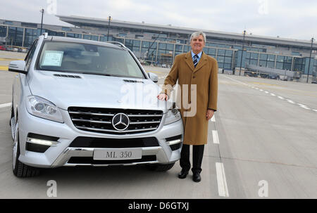 Der Leiter des Mercedes-Benz Niederlassung Berlin stellt neben einem Mercedes-Auto auf dem Gelände des neuen Berlin Brandenburg Airport in Schönefeld, Deutschland, 25. Januar 2012. Mercedes-Benz öffnet sich ein Airport Center und einen Service Punkt in der Abflughalle des Flughafens. Foto: Caroline Seidel Stockfoto