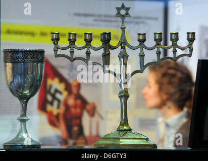 (DATEI) Ein Archivfoto vom 7. November 2011 zeigt eine Frau, die Stücke in der Ausstellung "Arisierung in Erfurt" betrachten einschließlich Menorah und einen Kelch aus dem Besitz einer ermordeten Familie in der Holocaust-Gedenkstätte "Topf & Söhne - die Ofen-Erbauer von Auschwitz" in Erfurt, Deutschland. Das restaurierte Gebäude soll am 27. Januar 2011 eröffnet werden. "Topf & Söhne" gebaut, das Fell Stockfoto