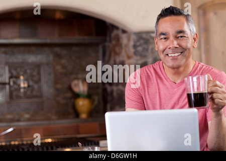 Mann mit Laptop beim Frühstück Stockfoto