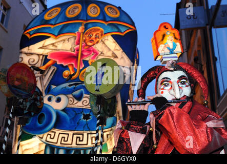 Narren schlendern durch die Strassen während des sogenannten Morgen Streiks ("Morgenstraich") in der Innenstadt von Basel, Schweiz, 27. Februar 2012. Die traditionelle Basler Fasnacht startete mit dem Morgen Streik am Montag nach Aschermittwoch, wenn alle Straßenlaternen in der Stadt alle bei 04:00 ausgeschaltet sind. Für 72 Stunden wird die Luft gefüllt mit dem Lärm der Rohre und Trommeln von marchi Stockfoto