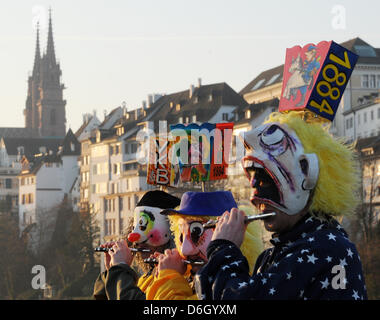 Narren schlendern durch die Strassen während des sogenannten Morgen Streiks ("Morgenstraich") in Basel, Schweiz, 27. Februar 2012. Die traditionelle Basler Fasnacht startete mit dem Morgen Streik am Montag nach Aschermittwoch, wenn alle Straßenlaternen in der Stadt alle bei 04:00 ausgeschaltet sind. Für 72 Stunden wird die Luft erfüllt vom Lärm der Pfeifen und Trommeln aus Marschmusik, Stockfoto