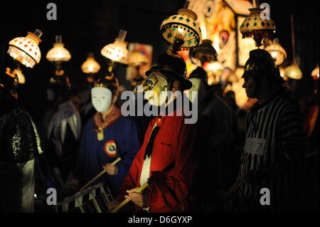 Narren schlendern durch die Strassen während des sogenannten Morgen Streiks ("Morgenstraich") in Basel, Schweiz, 27. Februar 2012. Die traditionelle Basler Fasnacht startete mit dem Morgen Streik am Montag nach Aschermittwoch, wenn alle Straßenlaternen in der Stadt alle bei 04:00 ausgeschaltet sind. Für 72 Stunden wird die Luft erfüllt vom Lärm der Pfeifen und Trommeln aus Marschmusik, Stockfoto