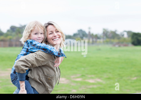 Mutter mit Sohn Huckepack im freien Stockfoto