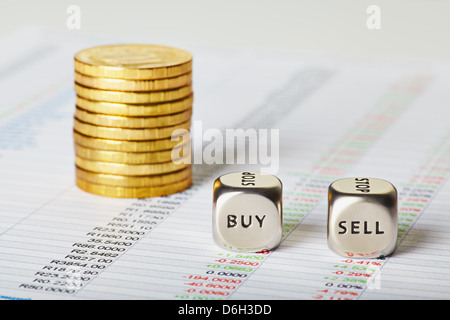 Finanz-Charts, goldene Münzen und Würfel Würfel mit Worten verkaufen kaufen. Selektiven Fokus Stockfoto