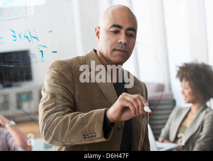 Geschäftsmann Zeichnung Graph in treffen Stockfoto