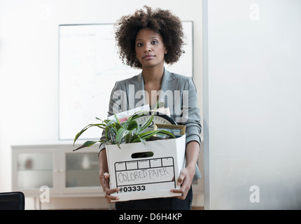 Geschäftsfrau, die Box im Büro einpacken Stockfoto