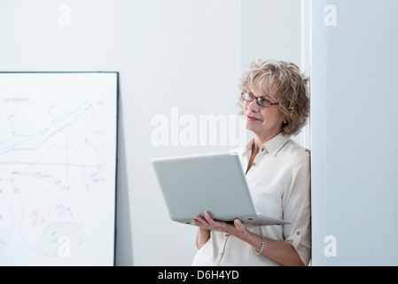 Geschäftsfrau mit Laptop im Büro Stockfoto