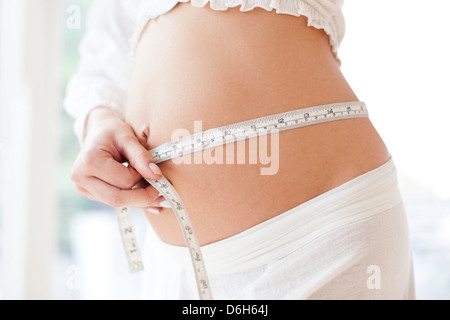 Schwangere Frau Messung ihres Bauches Stockfoto