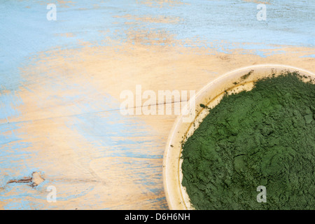 kleine Schale mit Hawaiian Spirulina Pulver gegen Holz Hintergrund Stockfoto