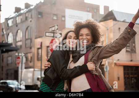 Frauen auf Stadtstraße umarmt Stockfoto