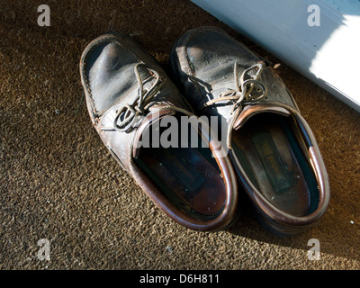 Angeschlagenen Schuhe auf der Fußmatte im Sonnenlicht Stockfoto