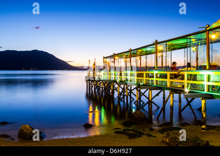 Pier von Ostradamus Restaurant in Ribeirao da Ilha Beach in der Abenddämmerung. Stockfoto