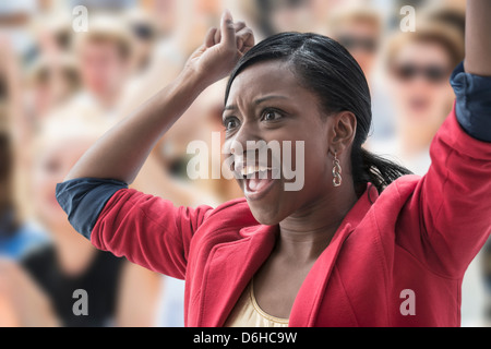 Erregte Frau in Menge Stockfoto