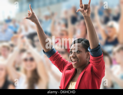 Erregte Frau in Menge, so dass Handbewegung Stockfoto