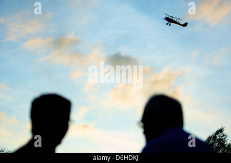 Biplane fliegt als Hochzeitsgeschenk für Braut und Bräutigam an Hochzeitsgästen vorbei Stockfoto