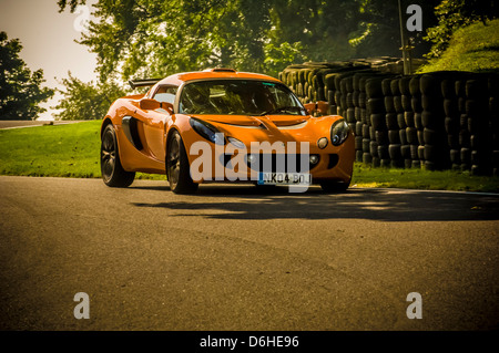 Orange Series 2 Lotus Exige Auto (aus einem niedrigen Winkel aufgenommen) auf der Strecke im Cadwell Park. Stockfoto