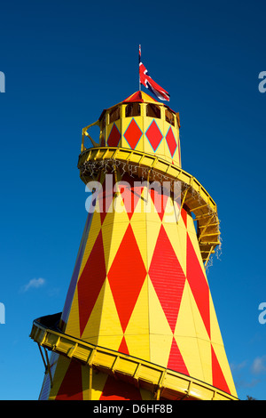 Rote und gelbe Helter Skelter Kirmes Jahrmarktsattraktion mit einem Union Jack gesetzt vor dem blauen Himmelshintergrund Stockfoto