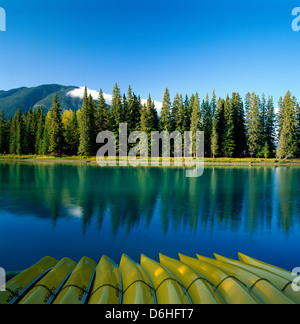 Gelben Kanus spiegeln die Reflexionen der immergrüne Bäume in den Bow River, Banff Nationalpark, Alberta, Kanada Stockfoto