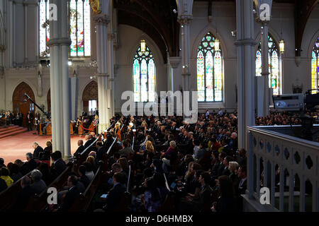 Menschen hören, wie US-Präsident Barack Obama auf eine interreligiöse Gebetsgottesdienst für Opfer von den Boston-Marathon-Angriff mit dem Titel "Healing Our City," spricht in der Kathedrale des Heiligen Kreuzes am 18. April 2013 in Boston, Massachusetts. Behörden untersuchen den Angriff auf den Boston-Marathon haben ihren Fokus verschoben, zum Auffinden der Person, die eine schwarze Tasche unten platziert und ging weg, kurz bevor die Bomben ging. Die zwei Bombenanschlägen auf 116-j hrige Boston Rennen, die in der Nähe der Marathon-Ziel-Geraden führte zu den Tod von drei Menschen und mehr als 170 Verletzte aufgetreten. Credi Stockfoto