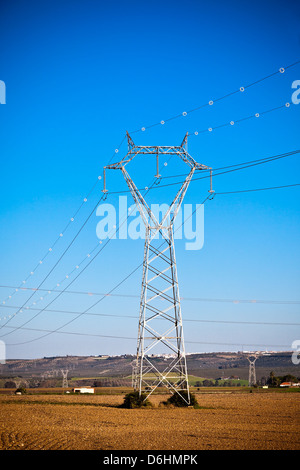 Strommasten macht gegen strahlend blauen Himmel in einer schönen Landschaft Stockfoto