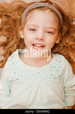 Glückliche kleine Mädchen am Boden liegend Stockfoto