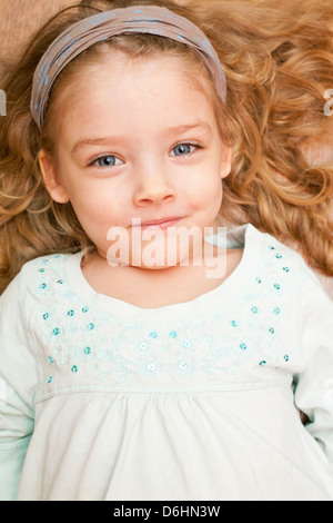 Glückliche kleine Mädchen am Boden liegend Stockfoto