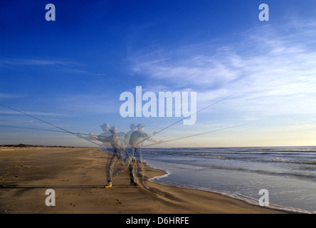 Surf-Fischer casting vom Strand am Norden Padre Island, Texas Stockfoto