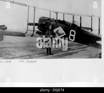 Dieses historische Foto zeigt Lt. Coney, der neben einem Curtiss JN-4 Jenny steht, einem berühmten Doppeldecker, der während des Ersten Weltkriegs ausgiebig für Training und Aufklärung eingesetzt wurde. Die Jenny war ein Schlüsselflugzeug in der frühen Luftfahrtgeschichte, das für seine Rolle bei der Ausbildung von Piloten während des Krieges bekannt war. Stockfoto