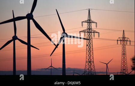 (Datei) - eine Archiv Bild, datiert 20. Februar 2012, elektrische Stromleitungen und Windkraftanlagen in der Abenddämmerung in der Nähe von Teachern, Deutschland. Pläne der Bundesregierung für die Energiewende und der Ausstieg aus der Kernenergie seit der Fukushima-Katastrophe übt Druck auf die großen Energieversorger in Deutschland. Fotos: Jan Woitas Stockfoto