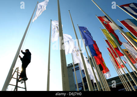 Mitglied Messepersonal hebt Flaggen der ausstellenden Länder vor dem Haupteingang zum Messegelände in Berlin, Deutschland, 6. März 2012. Rund 12.000 Aussteller aus 187 Ländern, die ihre bei der Travel Reiseangebote, trade Messe ITB Berlin vom 07. bis 11. März 2012. Foto: WOLFGANG KUMM Stockfoto