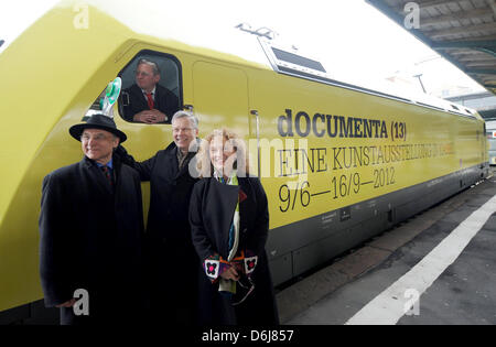 Documenta-Geschäftsführer Bernd Leifeld (L-R), Vertreter der Deutschen Bahn für Hessen Klaus Vornhusen, präsentieren künstlerischer Leiter der Documenta Carolyn Christov-Bakargiev, und einen elektronischen Zug Motor mit einem Eadvert für die Documenta XIII am Bahnhof Kulturbahnhof in Kassel, Deutschland, 7. März 2012. Der Triebwagen wird in den Intercity und Eurocity lange-Entfernung verwendet werden Stockfoto