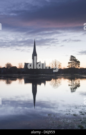 Kathedrale von Salisbury in der Morgendämmerung reflektiert in den überfluteten West Harnham Wässermatten, Salisbury, Wiltshire, England, UK Stockfoto