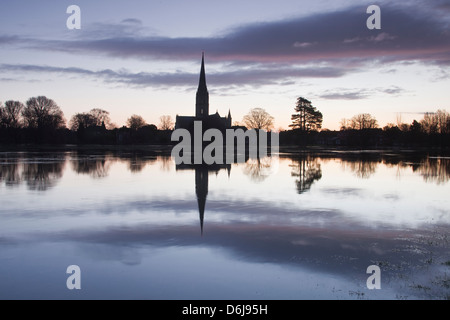 Kathedrale von Salisbury in der Morgendämmerung reflektiert in den überfluteten West Harnham Wässermatten, Salisbury, Wiltshire, England, UK Stockfoto
