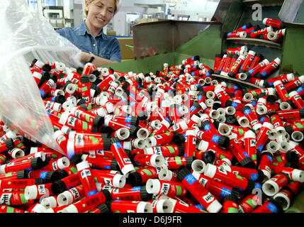 (Dpa-Datei) - ein Datei-Bild datiert 18. Februar 2004 zeigt eine Frau eine Füllmaschine mit Gehäusen von Klebstoff der Firma Henkel in einer Fabrik in Düsseldorf klebt. Henkel liefert ein Presse-Breifing Bilanzpressekonferenz am 8. März 2012. Foto: Rolf Vennenbernd Stockfoto