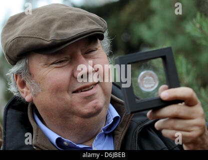 Direktor des Zoos Bernhard Blaszkiewitz präsentiert die "Knut - der Träumer-Gedenkmünze" ("Knut - der Traeumer Gedenkmuenze") an der Zoologische Garten in Berlin, Deutschland, 12. März 2012. Die Vorderseite der Münze zeigt das Knut-Denkmal, das im Zoo im Sommer eingerichtet wird, während die Rückseite das Wahrzeichen von Berlin zeigt. Foto: BRITTA PEDERSEN Stockfoto