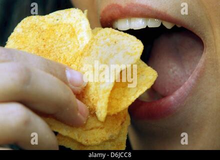 Datei - eine Archiv Bild datiert 4. Dezember 2002 zeigt eine junge Frau in Düsseldorf eine Handvoll Chips zu essen. UN-Experten sind der Meinung, dass alle Lebensmittel, die in größeren Mengen ungesund sind teurer werden sollte. Foto: Gero Breloer Stockfoto