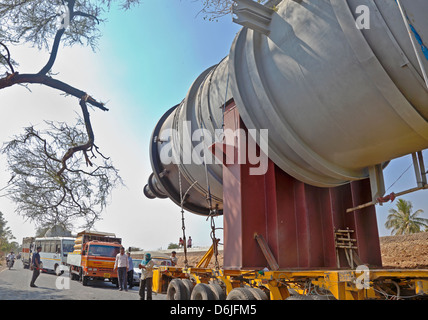 Horizontale waren Transporter Cargo stecken zwischen zwei Bäumen auf beiden Seiten einer von Bäumen gesäumten Straße, Notfalldienste übernehmen Stockfoto