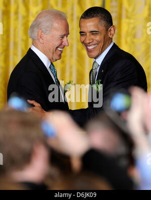 United States President Barack Obama (R) wird von US-Vizepräsident Joe Biden begrüßt, als er für einen Empfang für irische Premierminister Enda Kenny im East Room des weißen Hauses, 20. März 2012, in Washington, DC kommt. Obama und Kenny abgeschlossen als Arbeitstag Diskussionen über wirtschaftliche Angelegenheiten gewidmet Irlands friedenserhaltende Beteiligungen und außenpolitische Themen wie Syrien ein Stockfoto