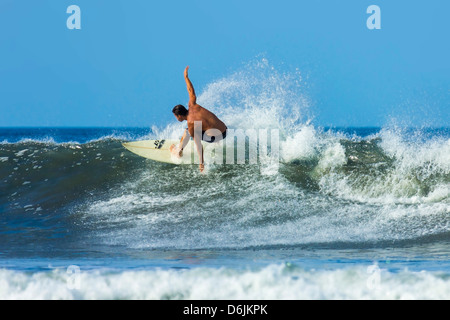 Surfer am Shortboard Welle am beliebten Playa Guiones Surf Beach, Nosara, Nicoya Halbinsel, Provinz Guanacaste, Costa Rica Stockfoto
