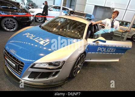 Polizist Angelika Reichelt steht neben einem getunten 620 PS Audi ABT R8 GTR Polizeiauto auf der Automobil Messe "Auto Trend 2012" in Rostock, Deutschland, 23. März 2012. Aus kommerziellen Gründen wurde das Auto als ein Polizeiauto ausgestattet, um zu zeigen, dass getunte Autos sicher und von der Polizei erlaubt sein können. 28 Unternehmen und 260 verschiedene Modelle präsentiert bis 25 März 20 Stockfoto