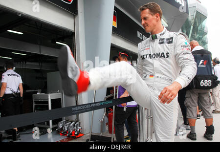 Deutsche Formel1 Rennfahrer Michael Schumacher von Mercedes AMG kommt bei der Team-Garage vor dem dritten Training auf dem Sepang Circuit außerhalb Kuala Lumpur, Malaysia, 24. März 2012. Der Formel 1 Grand Prix von Malaysia stattfinden am 25. März 2012. Foto: Jens Büttner Stockfoto