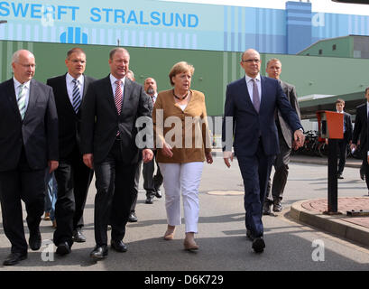 Bundeskanzlerin Angela Merkel, Premier of Mecklenburg-Western Pomerania Erwin Sellering (R) und Manager von P + S-Petkumer in Stralsund und Wolgast Ruediger Fuchs (2 L) geben ein Statement am Eingang der Volksweft-Werft in Stralsund, Deutschland, 21. August 2012. Merkel nahm Teil in einer Besprechung über die Zukunft der Schiffbau-Unternehmen, wo durften Medienvertreter nicht Stockfoto