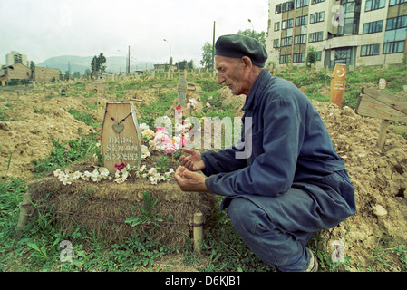 Ein muslimischer Mann an einem Grab im Zentrum Stadt, Sarajevo, Bosnien und Herzegowina beten Stockfoto