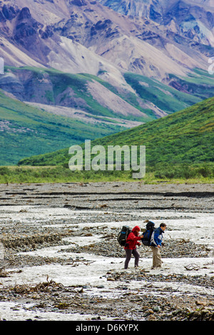 Zwei Backpacker sorgfältig Fjord Toklat River, Denali National Park, Alaska, USA Stockfoto