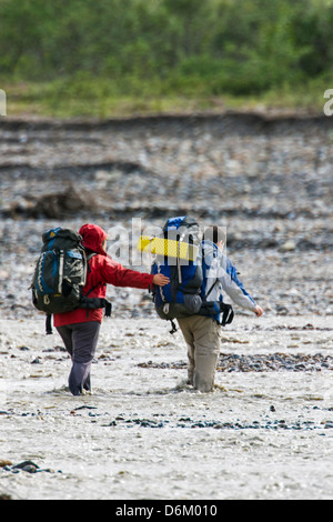 Zwei Backpacker sorgfältig Fjord Toklat River, Denali National Park, Alaska, USA Stockfoto