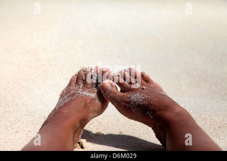 Weibliche verschmutzt barfüßigen Beinen im sand Stockfoto