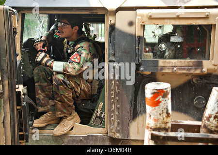 Ein Afghan National Army Special Forces Soldat sorgt für Sicherheit während lokalen afghanischen Polizisten mit einem Team des Innenministeriums Verarbeitung 12. April 2013 in der Provinz Helmand, Afghanistan gerecht zu werden. Stockfoto