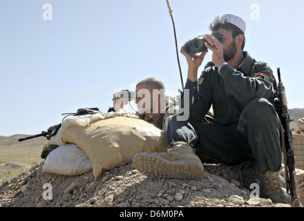Ein US-Marine mit der Kajaki Polizei-Advisory-Team arbeitet mit ein einheitliches afghanischer Polizist auf einen Bereich Umfrage 30. März 2013 in der Nähe von Outpost Torioba, Provinz Helmand, Afghanistan. Stockfoto