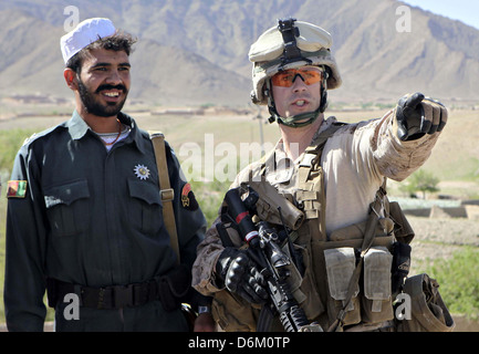 Ein US-Marine mit dem Kajaki Polizei Advisory Team spricht mit ein afghanischer Polizist Uniform 30. März 2013 in der Nähe von Outpost Torioba, Provinz Helmand, Afghanistan. Stockfoto